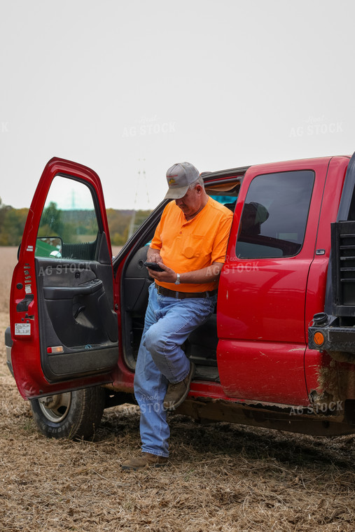 Farmer Leaning on Truck with Phone 52569
