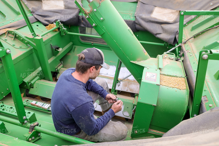 Farmer Repairing Combine 52572