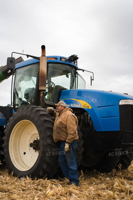 Farmer in Field Standing By Tractor 115043
