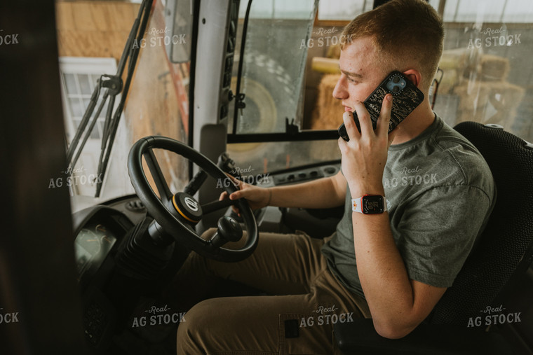 Young Farmer Talks on Phone in Tractor Cab 7550