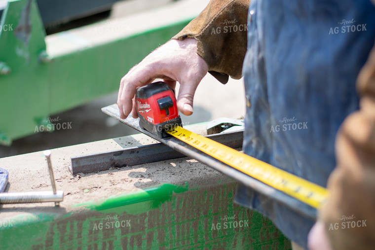 Farmer Measuring Metal for Machinery Repair 50363