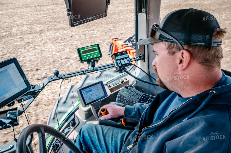 Farmer Looks at Equipment Monitors While Planting Field 56639