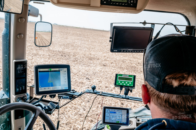 Farmer Looks at Equipment Monitors While Planting Field 56640