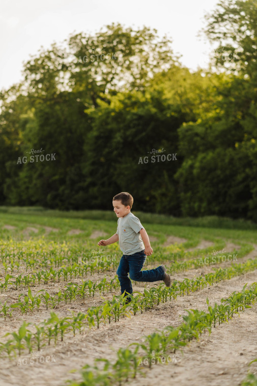 Farm Kid Running in Early Growth Corn Field 115060