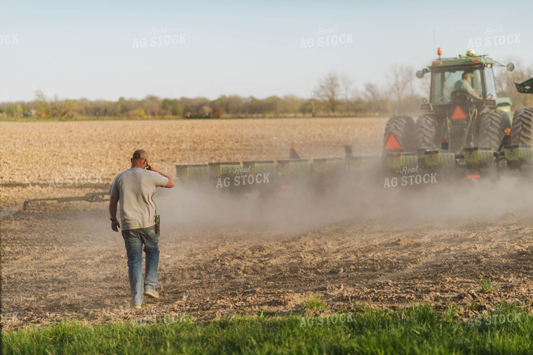 Farmer Approaches Field as Tractor Plants in Background 115071