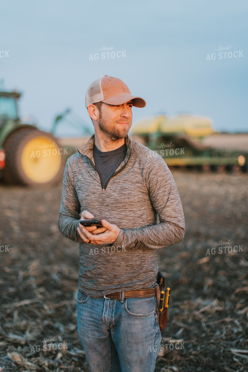 Farmer using Phone in Field by Planter 8248