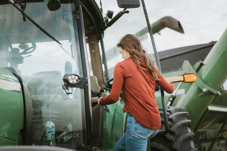 Female Farmer Cimbing into Tractor 8542