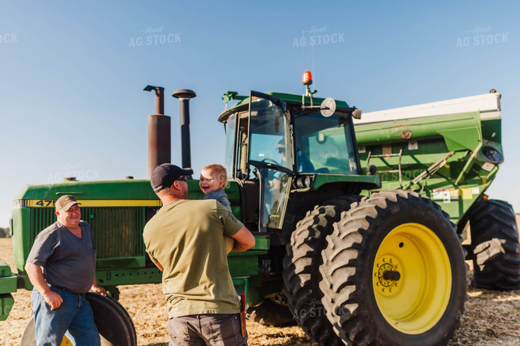 Farmer Holding Kid by Tractor 115091