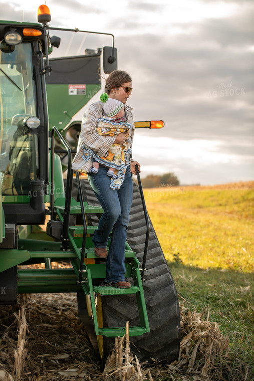 Female Farmer with Baby Climbing out of Tractor 76542