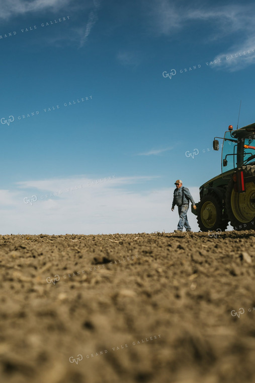 Farmer Climbing out of Tractor with Planter 4102