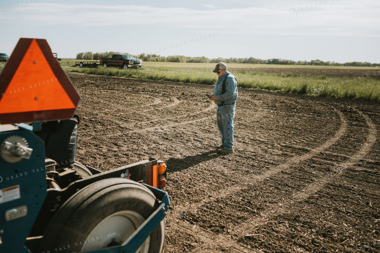 Farmer Looking at Phone in Field 4123