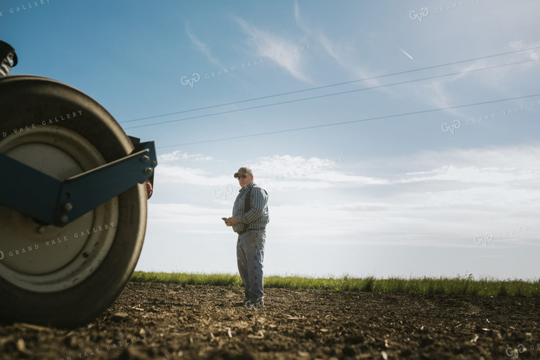 Farmer Looking at Phone in Field 4124