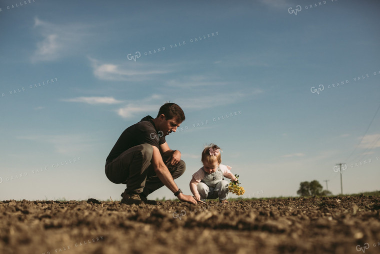 Farmer and Daughter Checking Seed Depth 4176