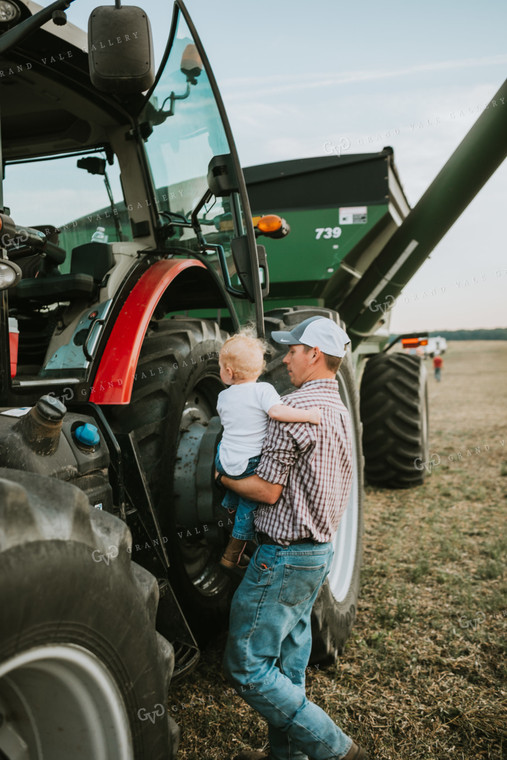 Farmer Taking Farm Kid into Tractor with Grain Cart 4982
