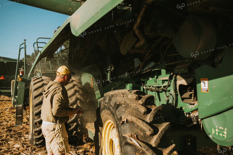 Farmer Cleaning Combine with Air Hose 4664