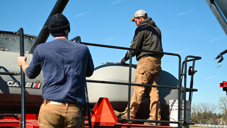 Farmer Loading the Planter with the Seed Tender 25094