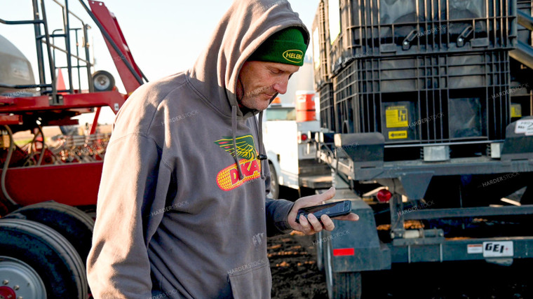 Farmer Talking on Phone with Loading Planter 25187