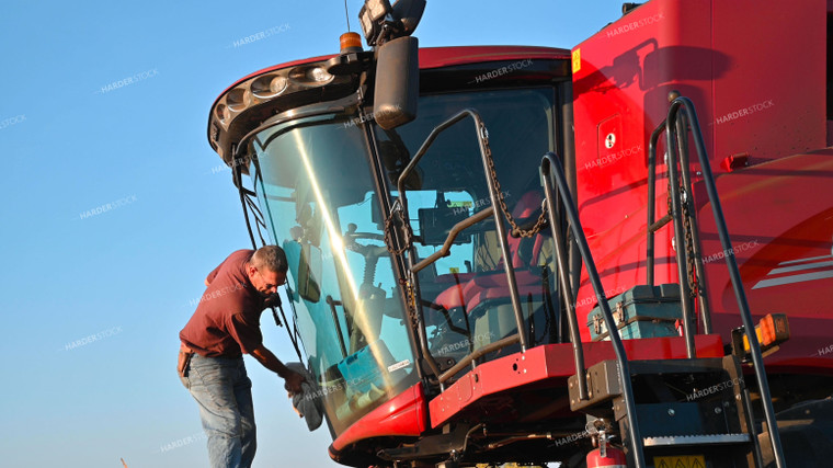 Farmer Cleaning Dust off Combine 25509