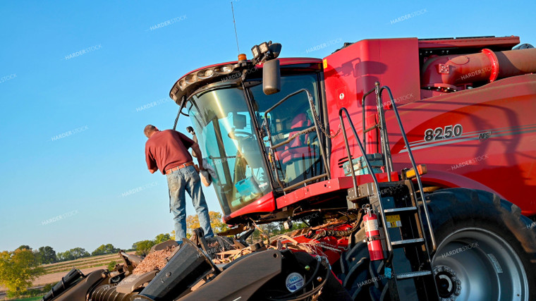 Farmer Cleaning Dust off Combine 25531