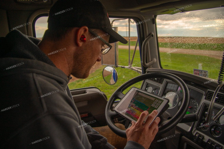 Farmer Checking Tablet in Semi Cab 25557