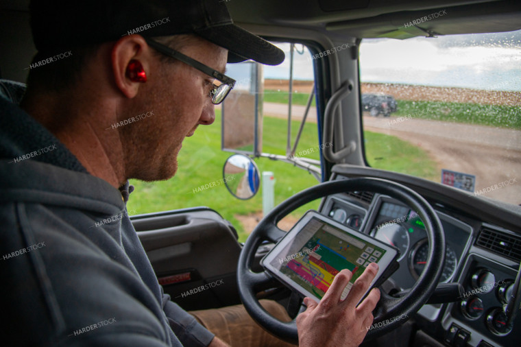 Farmer Checking Tablet in Semi Cab 25558