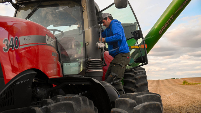 Farmer Climbing into Tractor Cab 25758