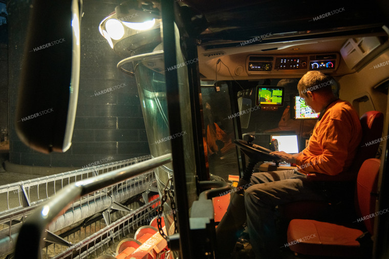 Farmer Cleaning Dust off Combine at Night 25803