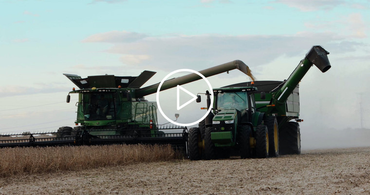 Combine Unloading On the Go into Grain Cart with Female Farmer 3961