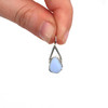 Cornflower Milk Glass Lunar Drop Charm held to the light