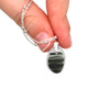 Gray Waves Ultra Rare Sea Glass Drop Necklace held to the light