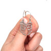 Sterling Silver Angel Wing Earrings on model for color reference.