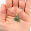 Green Small Sand Dollar Sea Glass Charm Necklace held up on model's palm for color and details