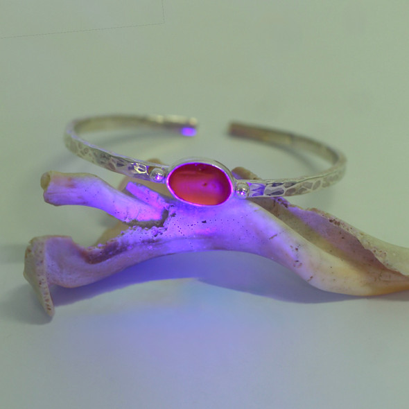Red Sea Glass Beaded Hammered Cuff Bracelet under a black light Red Sea Glass Beaded Hammered Cuff Bracelet under a black light