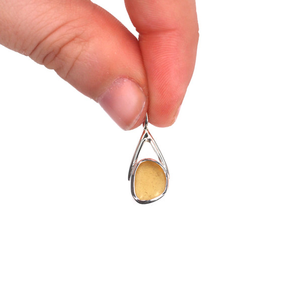 Amber Honey Half-Moon Sea Glass Lunar Drop Charm held to the light