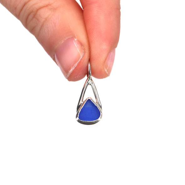 Cobalt Triangle Sea Glass Lunar Drop Charm held to the light