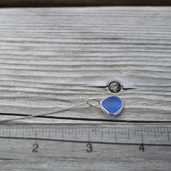 Cornflower Organic Round Sea Glass Charm Necklace on ruler up close
