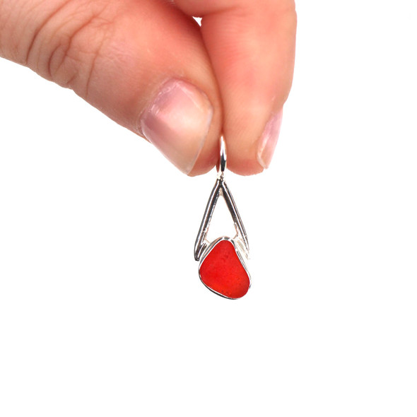 Red Bright Sea Glass Lunar Drop Charm held to the light