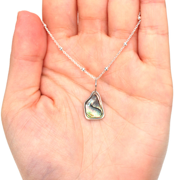 Abalone Wave Charm on model for color reference.