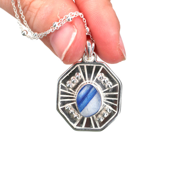 Blue Sapphire Striped Ultra Rare Sea Glass Starburst Necklace held to the light