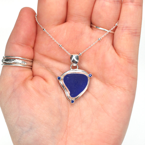 Cobalt Sea Glass and Sapphire Triangle Necklace on model for color reference. Cobalt Sea Glass and Sapphire Triangle Necklace on model for color reference.