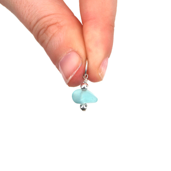 Sea Glass Dainty Drop Charm held to the light