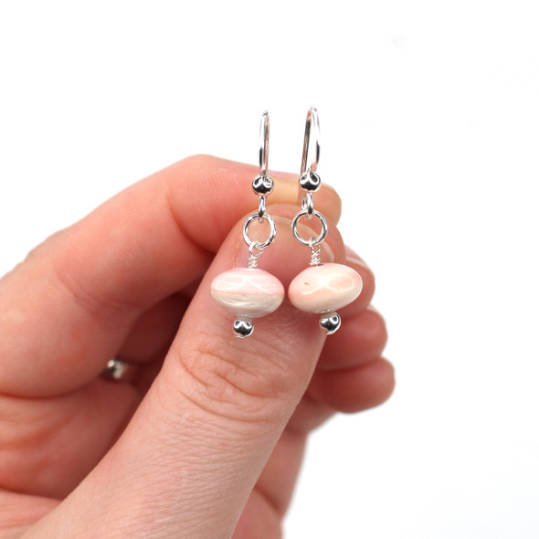 Conch Shell Dainty Drop Earrings on model for color reference.
