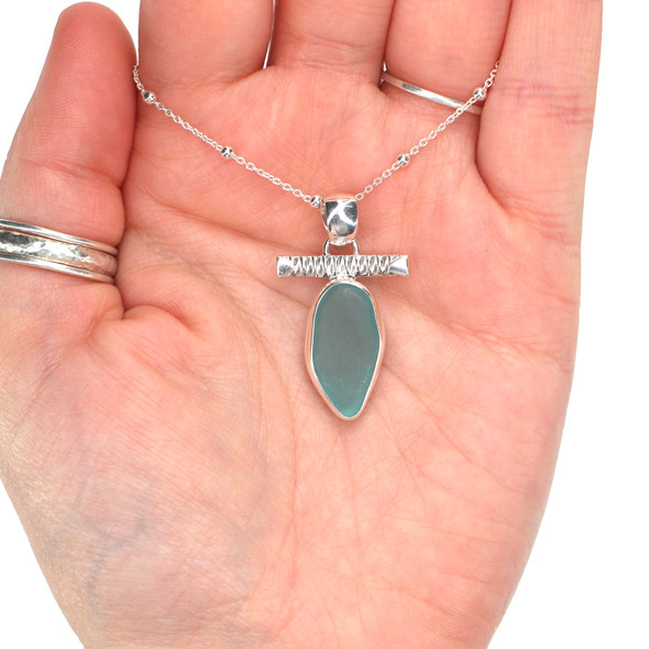 Aqua Oval Sea Glass Toggle Bar Necklace on model for color reference. Aqua Oval Sea Glass Toggle Bar Necklace on model for color reference.