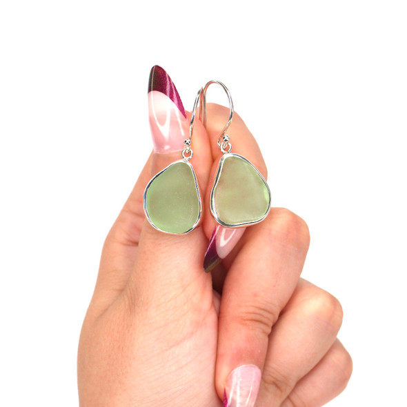 Seafoam Bright Triangle Drop Sea Glass Earrings on model for color reference. Seafoam Bright Triangle Drop Sea Glass Earrings on model for color reference.