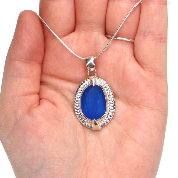 Cobalt Sea Glass Rising Sun Necklace on model for color reference. Cobalt Sea Glass Rising Sun Necklace on model for color reference.