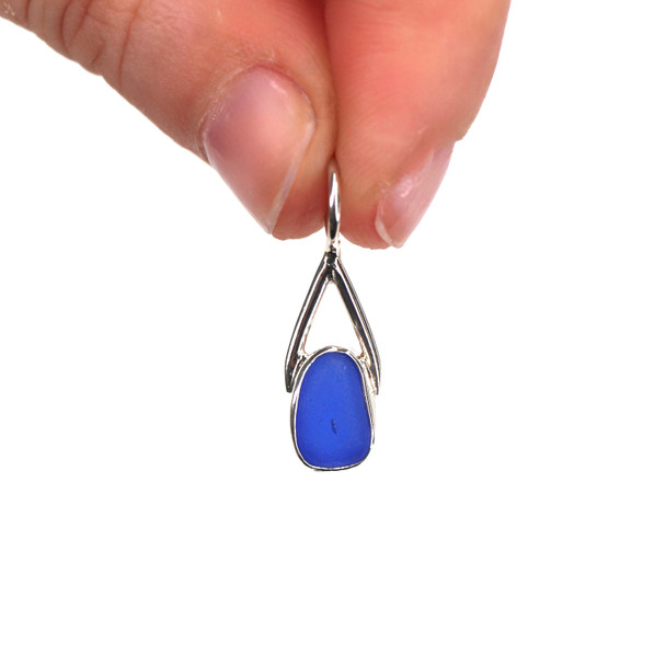 Cobalt Oval Sea Glass Lunar Drop Charm held to the light