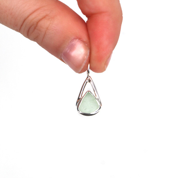 Seafoam Triangle Sea Glass Lunar Drop Charm held to the light