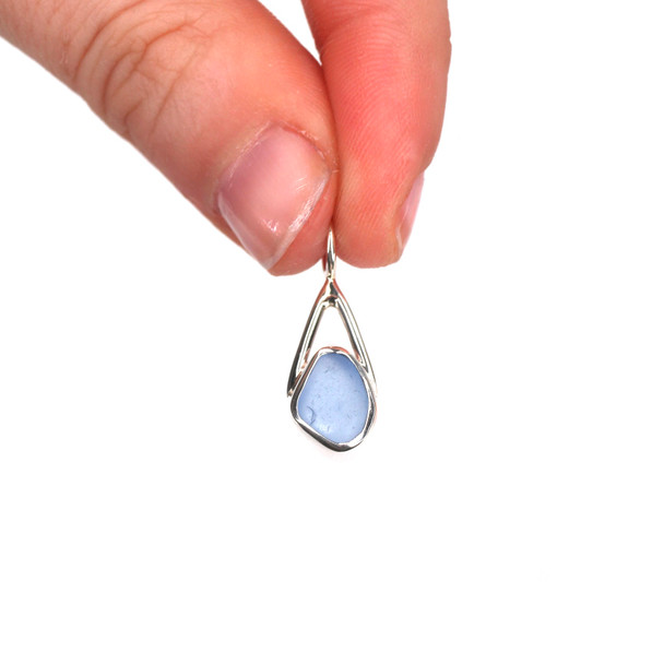 Cornflower Half-Moon Sea Glass Lunar Drop Charm held to the light