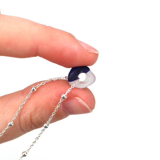 Deep Blue Ultra Rare Sea Glass Simple Necklace held to the light