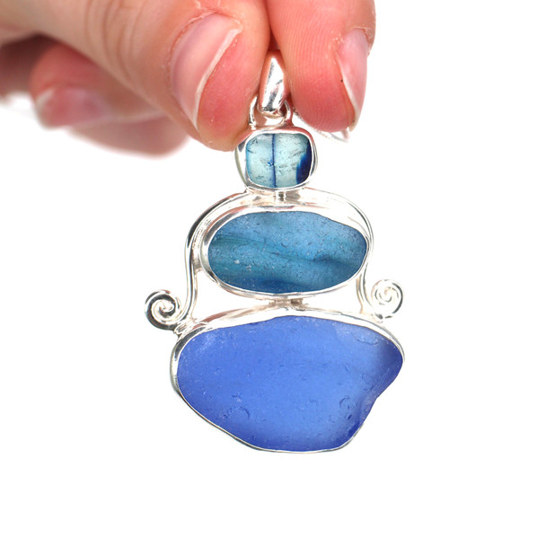 Turquoise Blues Ultra Rare Sea Glass Three Tier Swirl Necklace held to the light